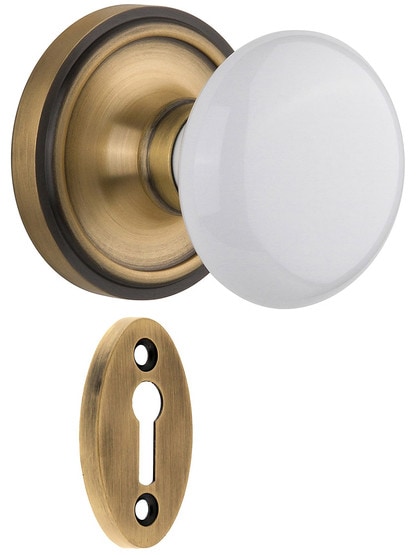 Classic Rosette Mortise Lock Set With White Porcelain Door Knobs in Antique Brass.